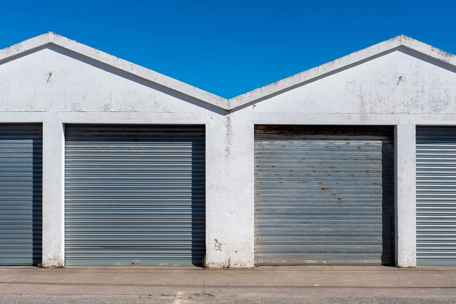 shed vs garage comparison — a wood storage shed beside a detached garage