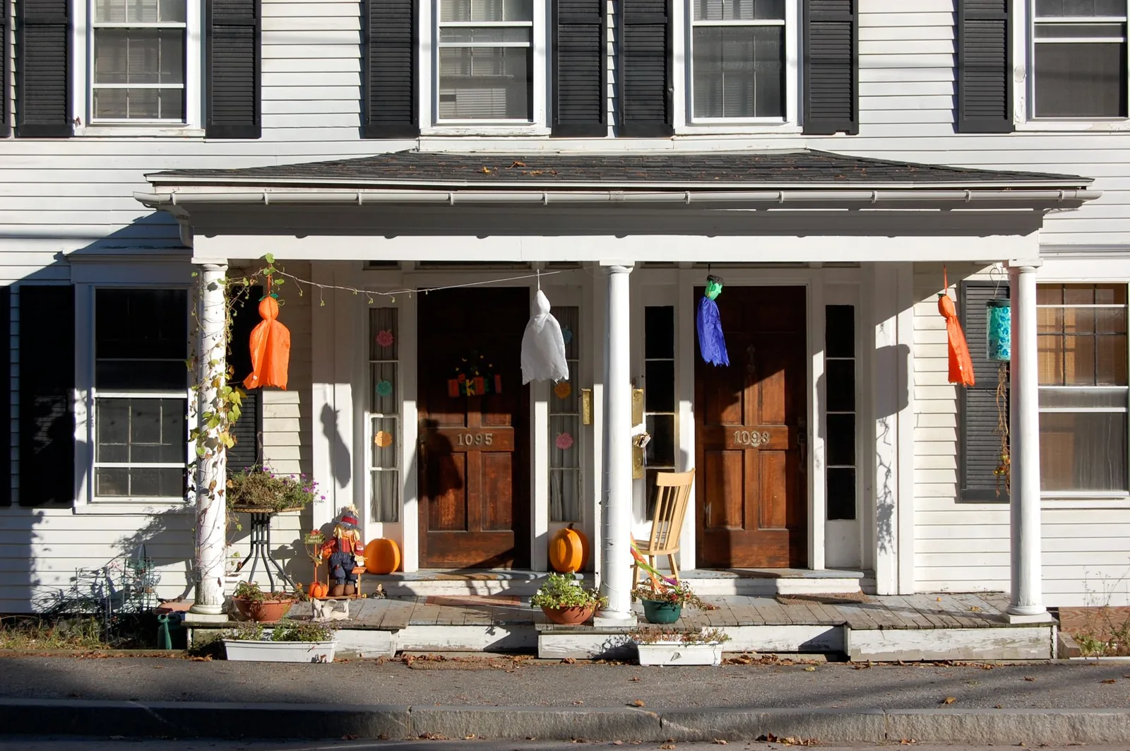 front porch cost — a covered front porch with wooden columns and a porch swing
