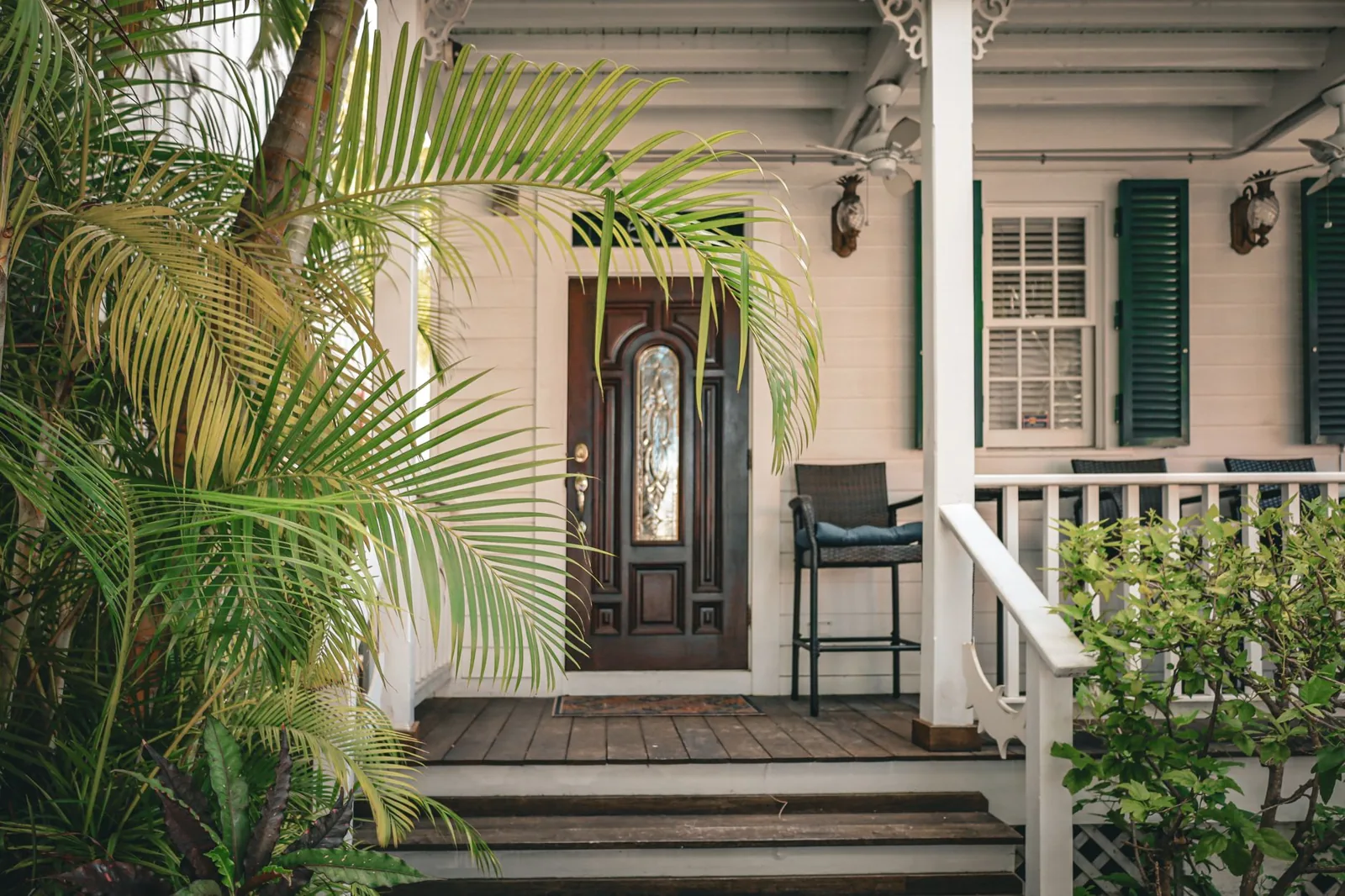 An open front porch with steps, planters, and a wooden floor